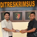 Ps Panit 2 Unit 1 Subdit 5 Ditreskrimsus Polda Papua Barat Daya, Muhammad Rafli Akbar, (kiri), saat menyerahkan kembali uang kerugian korban penipuan online di Mapolda Papua Barat Daya, Kota Sorong