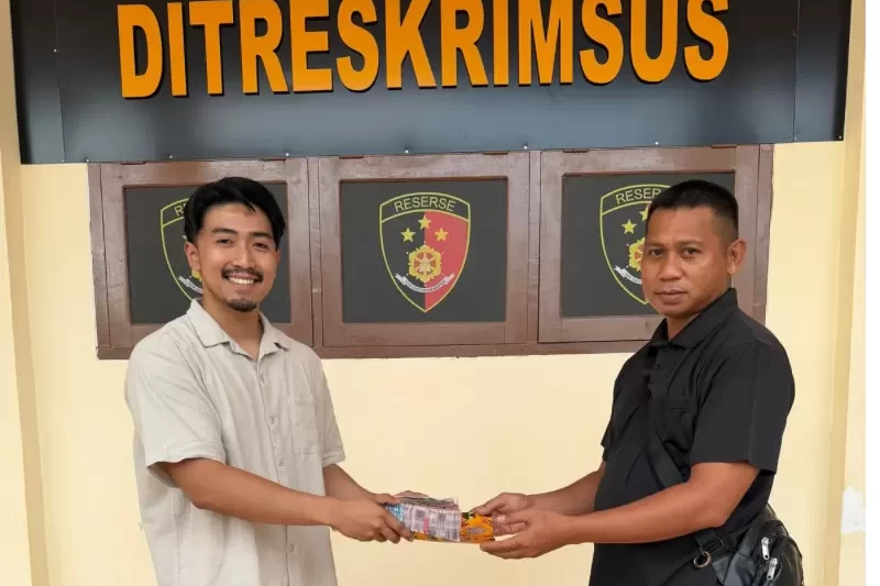 Ps Panit 2 Unit 1 Subdit 5 Ditreskrimsus Polda Papua Barat Daya, Muhammad Rafli Akbar, (kiri), saat menyerahkan kembali uang kerugian korban penipuan online di Mapolda Papua Barat Daya, Kota Sorong